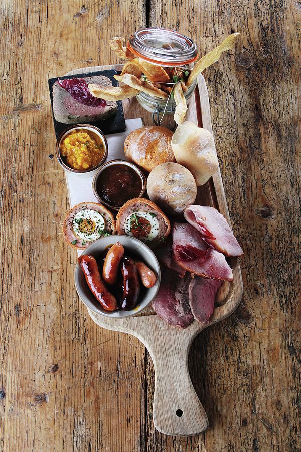 A Ploughmans Lunch Platter Of Ham, Sausages, Scotch Eggs, Chutney, Pickle And Bread Rolls england Photograph by Neil Langan