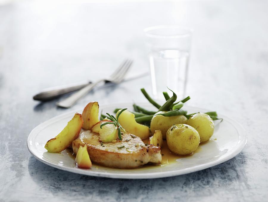 A Pork Chop With Potatoes, Green Beans And Apple Wedges Photograph by Mikkel Adsbl