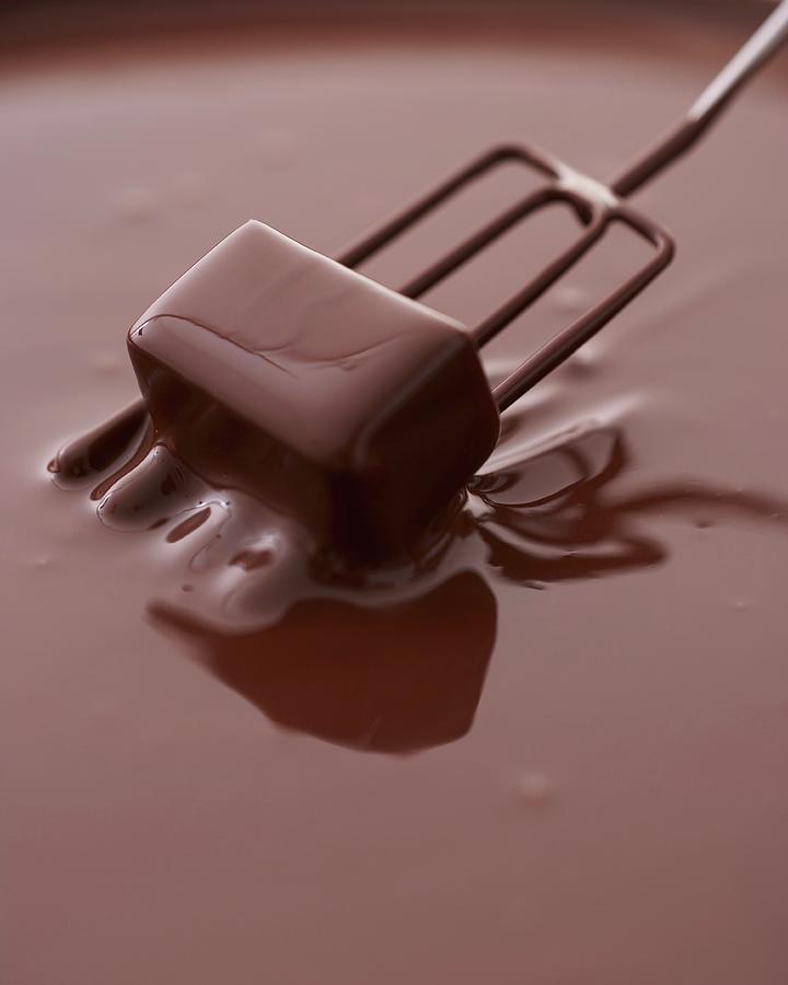 A Praline Being Dipped Into Chocolate Photograph by Oliver Brachat