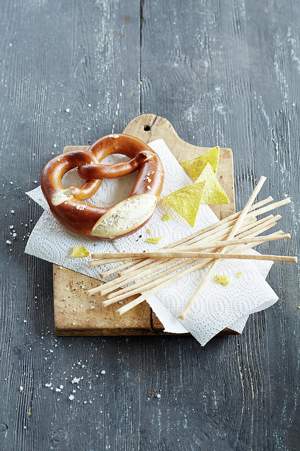 A Pretzel, Grissini And Tacos On A Chopping Board Photograph by Rafael Pranschke