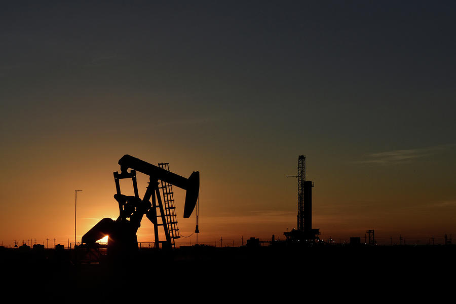 A Pump Jack Operates in Front Photograph by Nick Oxford - Fine Art America