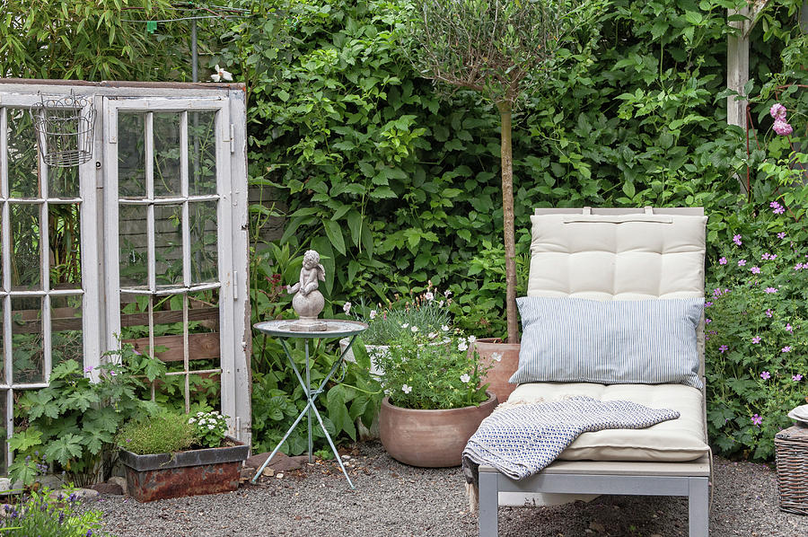 A Quiet Corner In The Garden With A Sun Lounger, Antique Window, And Decorations Photograph by Gudrun Itt