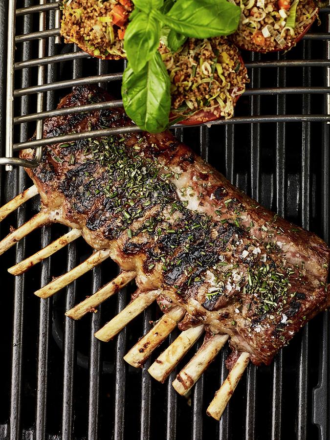 A Rack Of Lamb With Herbs And Stuffed Tomatoes On A Barbecue Photograph by Herbert Lehmann