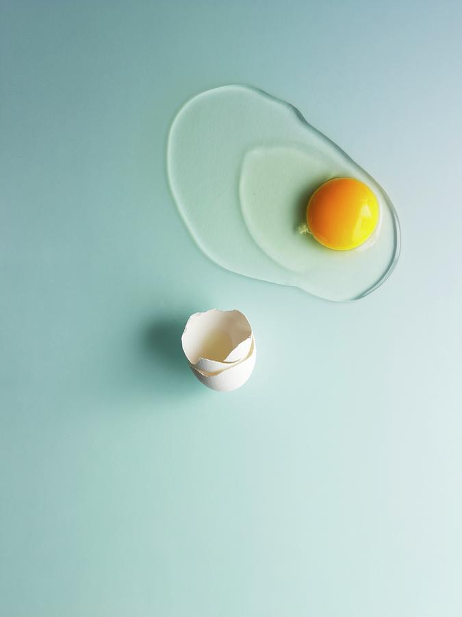 A Raw Egg On A Pale Blue Surface Photograph by Kng, Ruth