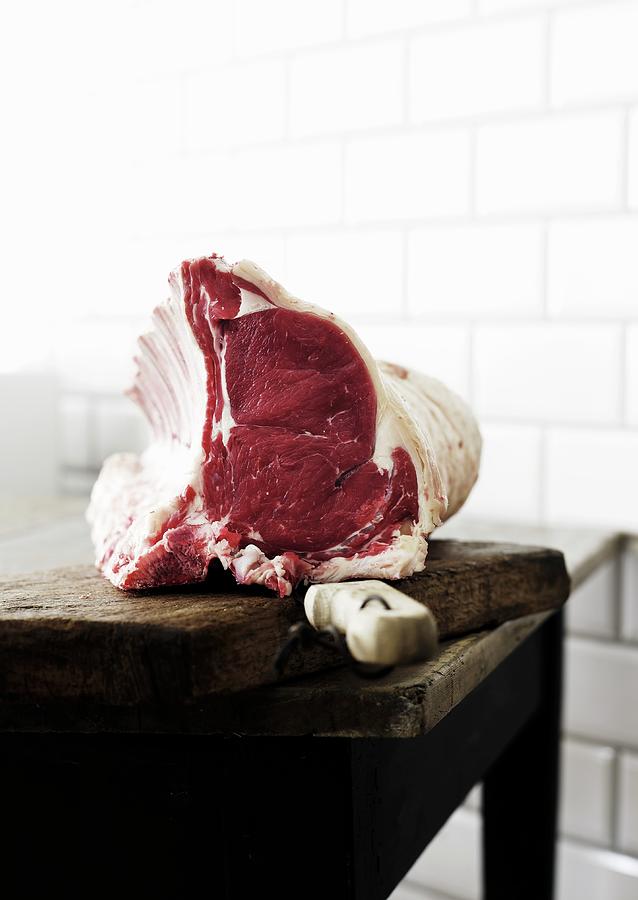 A Raw Rack Of Beef With A Knife On A Chopping Board Photograph by Mikkel Adsbl