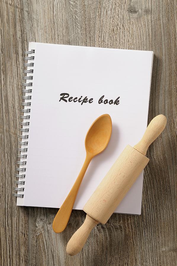 A Recipe Book, A Wooden Spoon And A Rolling Pin Photograph by Jean-christophe Riou