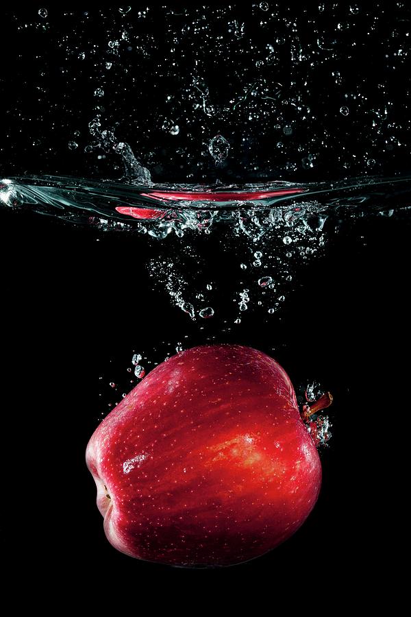 A Red Apple Falling In Water With A Splash Photograph by Tom Regester