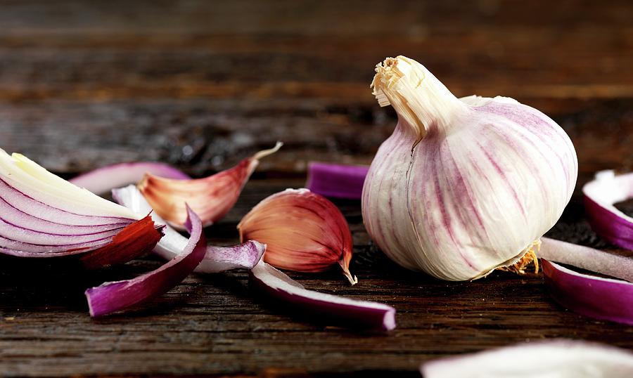 A Red Onion And Garlic On A Wooden Surface Photograph by Robert Morris