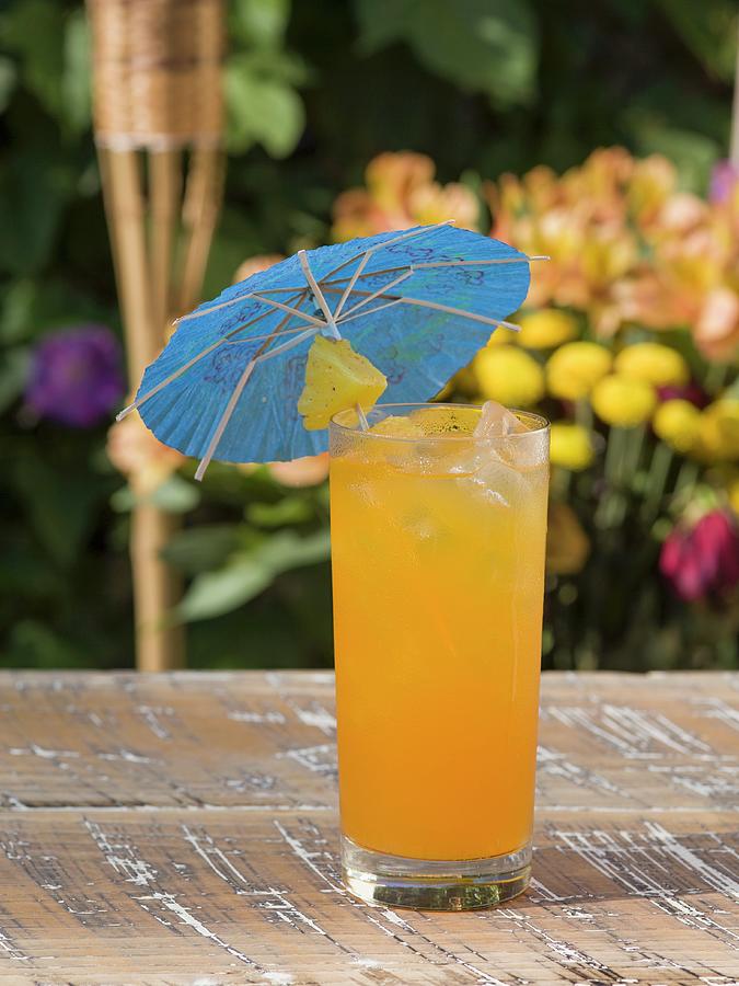 A Refreshing Fruit Cocktail With A Pineapple And A Paper Umbrella Photograph by Don Crossland