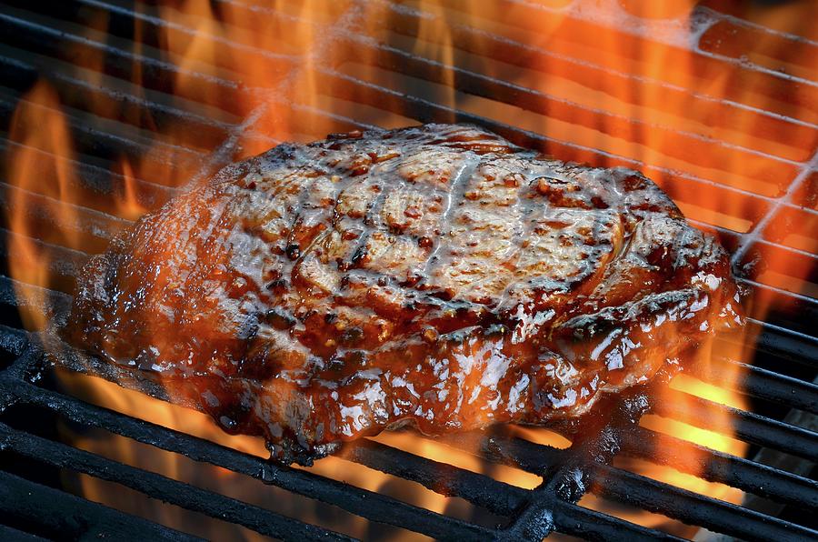 A Ribeye Steak On A Flaming Barbecue Photograph by Brian Enright