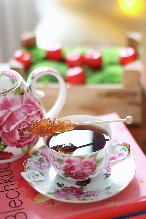 A Rock Candy Stick On A Rose Patterned Tea Cup Photograph by Sylvia E.k Photography