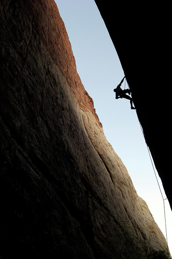 A Rock Climber Is Silhouetted As He Photograph by Jared Mcmillen