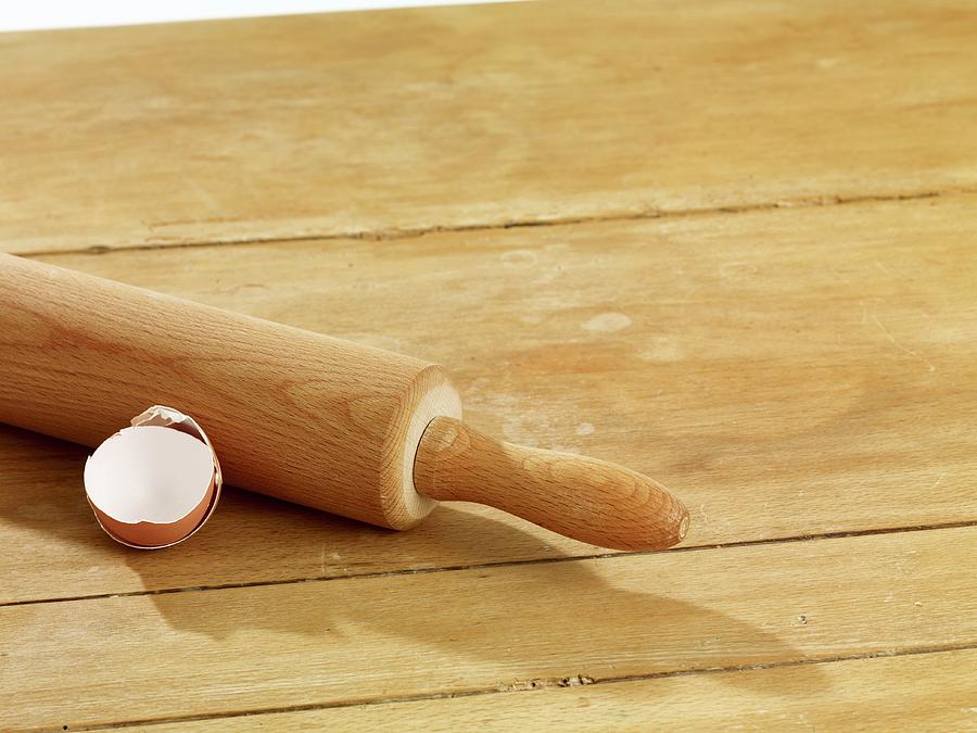 A Rolling Pin And An Eggshell On A Wooden Surface Photograph by Studio R. Schmitz