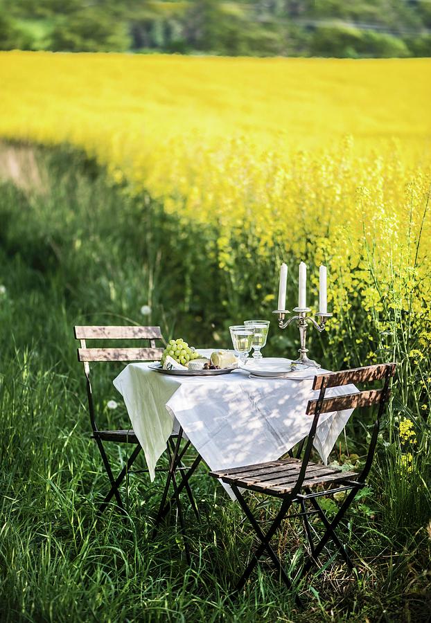 A Romantic Candlelight Dinner By A Field Of Flowering Oilseed Rape Photograph by Fotografie-lucie-eisenmann