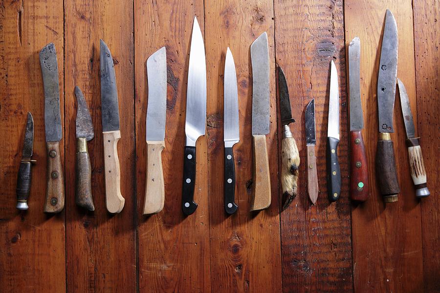 A Row Of Different Knives On A Wooden Surface Photograph by Frank Weymann