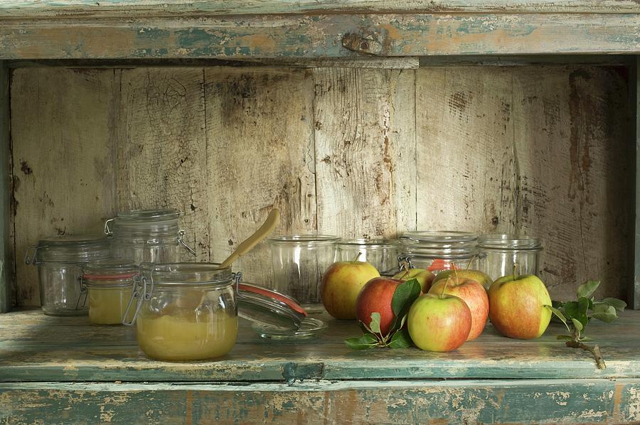 A Rustic Arrangement Of Apple Compote, Preserving Jars And Fresh Apples Photograph by Achim Sass