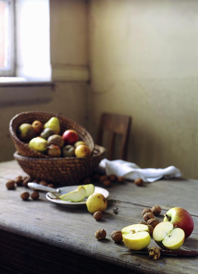 A Rustic Arrangement Of Apples And Nuts On A Wooden Table Photograph by Linda Sonntag
