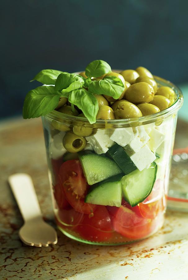 A Salad Of Tomatoes, Cucumbers, Feta, Green Olives And Basil In A Glass Photograph by Valeria Aksakova