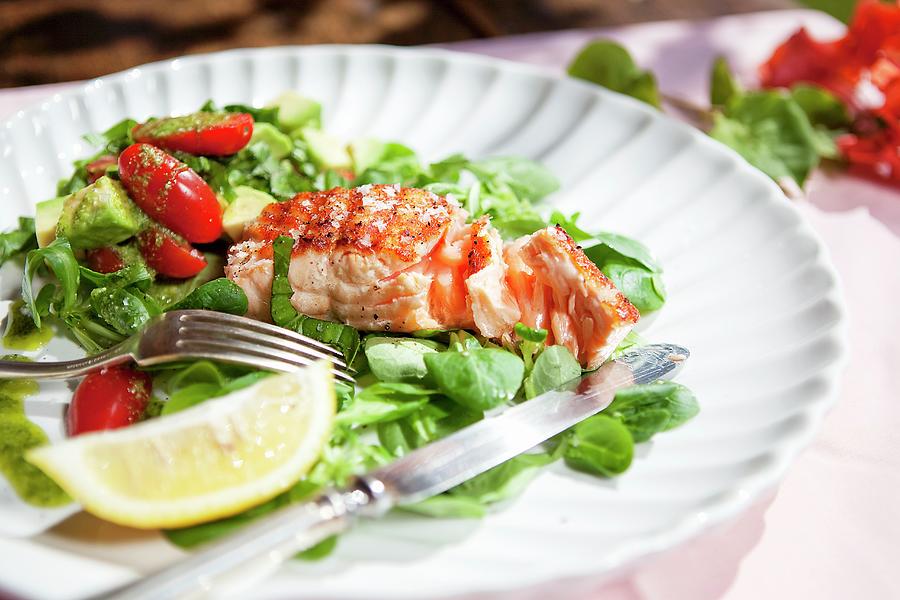 A Salmon Fillet On A Bed Of Lambs Lettuce With Tomatoes, Avocado And Pesto Photograph by Daly, Zara