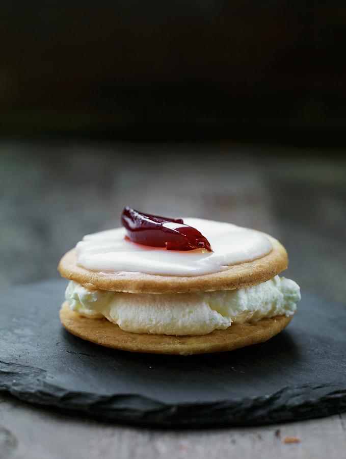 A Sandwich Biscuit Filled With Cream And Topped With Lemon Glaze And Raspberry Jelly Photograph by Lars Ranek
