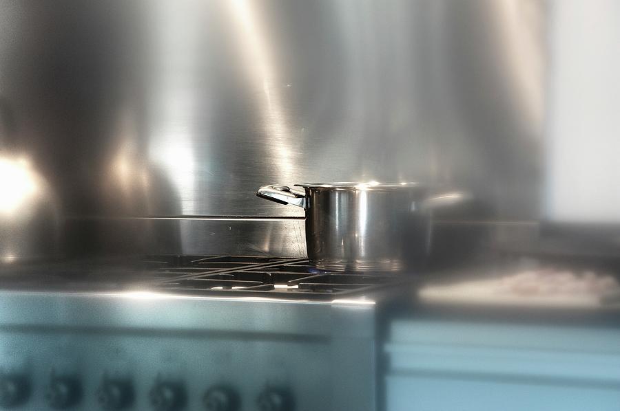 A Saucepan On A Gas Hob Photograph by Kaktusfactory