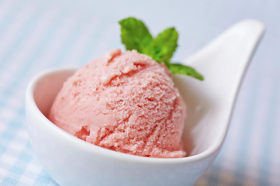 A Scoop Of Home-made Raspberry Ice Cream With Mint Leaves Photograph by Robert Kneschke