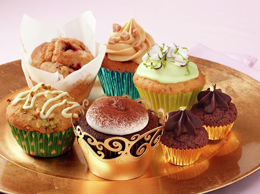 A Selection Of Different Luxury Cupcakes On A Gold Plate Sitting On A Pink Background Photograph by Stuart Macgregor