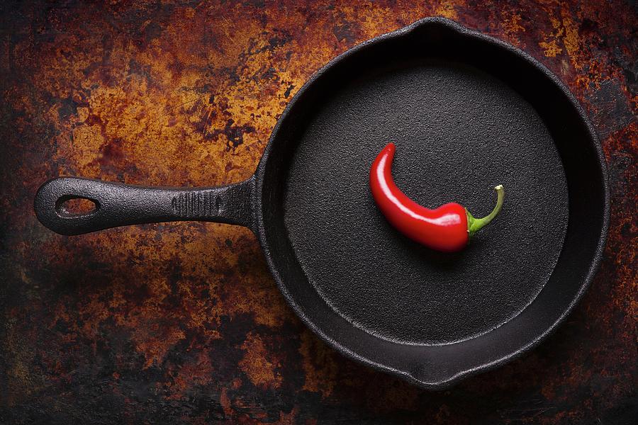 A Single Red Chilli Pepper In A Cast Iron Pan seen From Above Photograph by Brian Enright