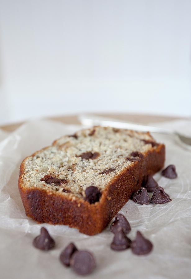 A Slice Of Banana Bread With Chocolate Chips On A Piece Of Parchment Paper Photograph by Ryla Campbell