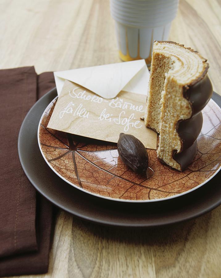 A Slice Of Baumkuchen german Layer Cake And An Envelope With Writing On It, On A Dish With A Reticulated Design Photograph by Matteo Manduzio