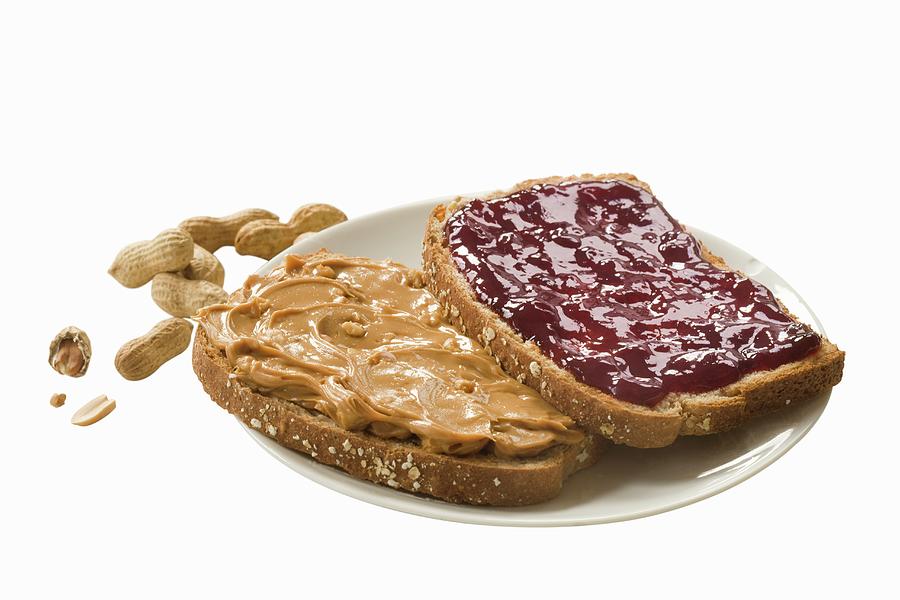 A Slice Of Bread Spread With Peanut Butter And Another Spread With Jam Photograph by Colin Cooke