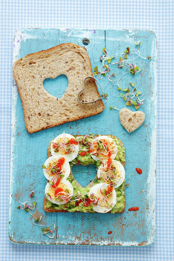 A Slice Of Bread Topped With Guacamole, Hard-boiled Egg, Bean Sprouts And Sriracha Sauce With A Heart Cut Out In The Middle Photograph by Rua Castilho