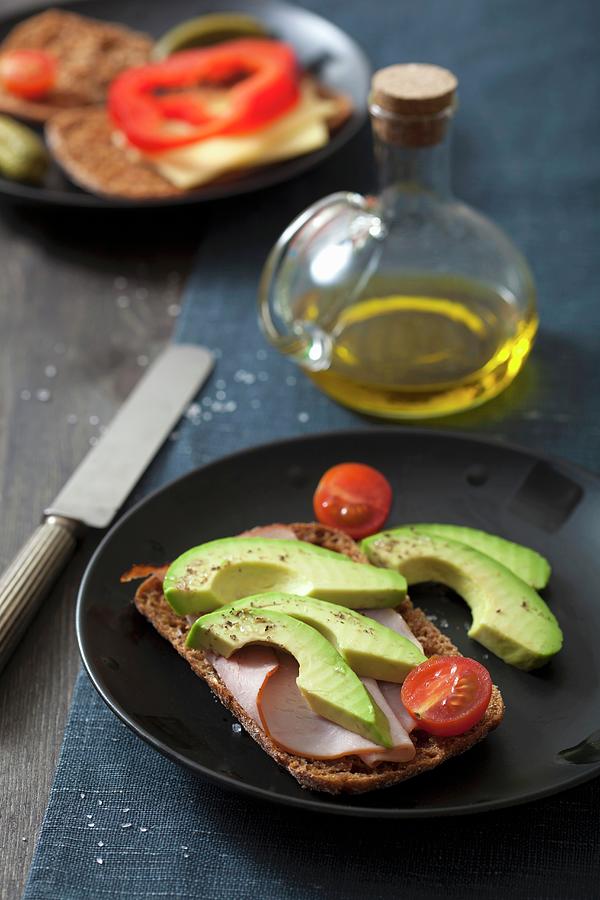 A Slice Of Bread Topped With Ham, With Avocado And Tomatoes, And A Slice Of Bread Topped With Cheese And Peppers Photograph by Miltsova, Olga