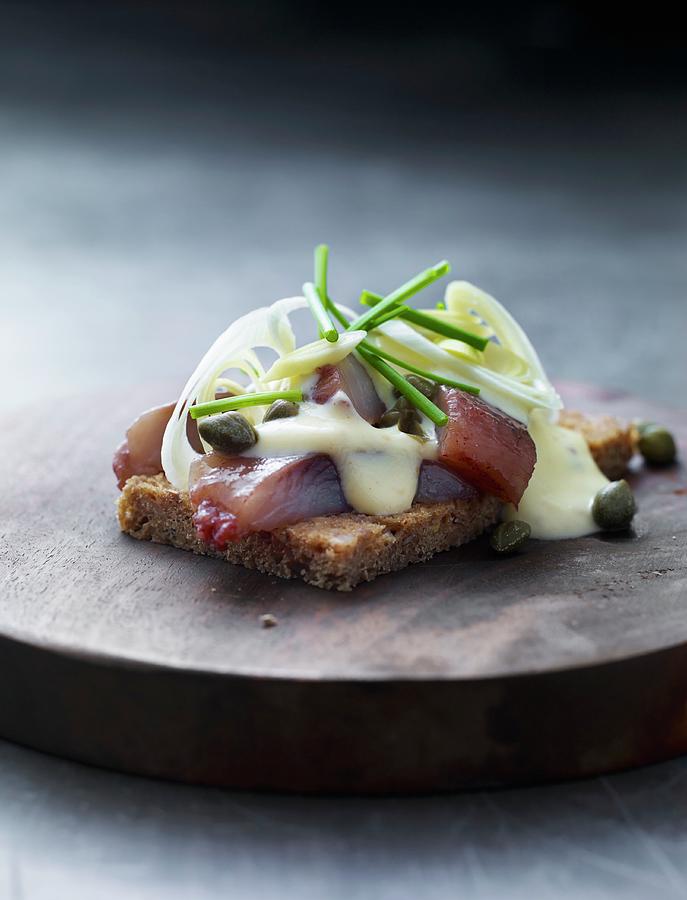 A Slice Of Bread Topped With Herring, Remoulade And Capers Photograph by Lars Ranek