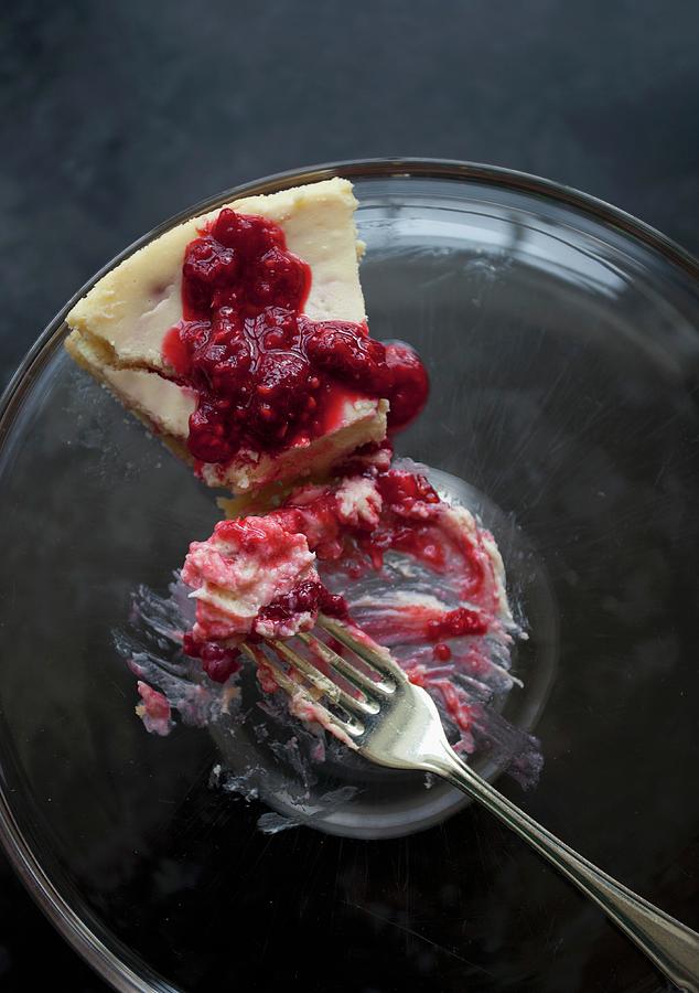A Slice Of Cheesecake With Raspberry Sauce On A Glass Plate With A Fork With A Bite Taken Out Photograph by Ryla Campbell