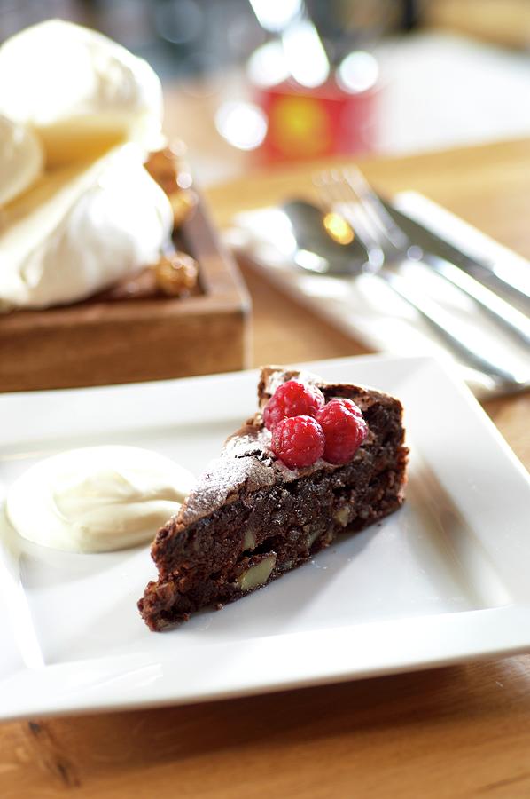 A Slice Of Chocolate And Almond Torte With Raspberries Photograph by Tim Green