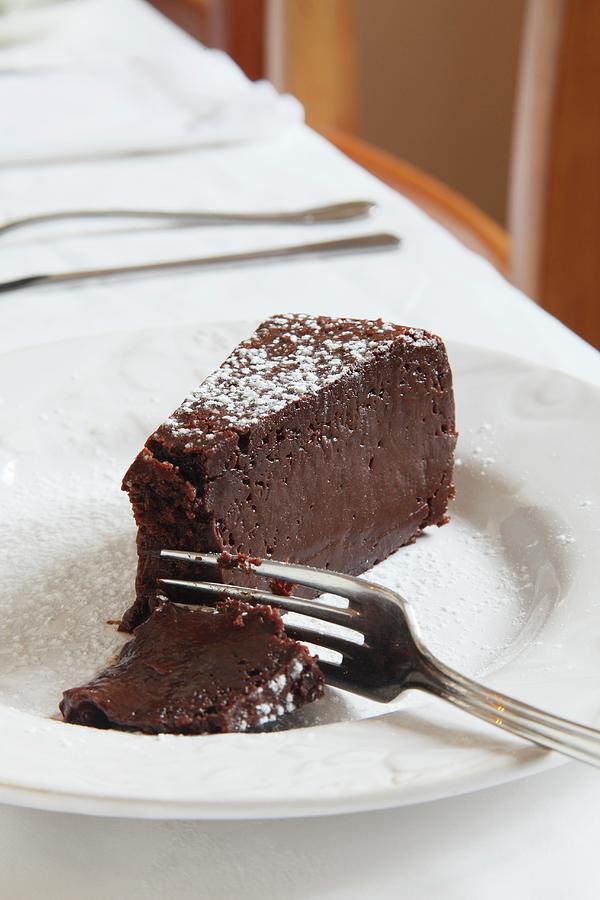 A Slice Of Chocolate Cake On A Black Background Photograph by Simon ...