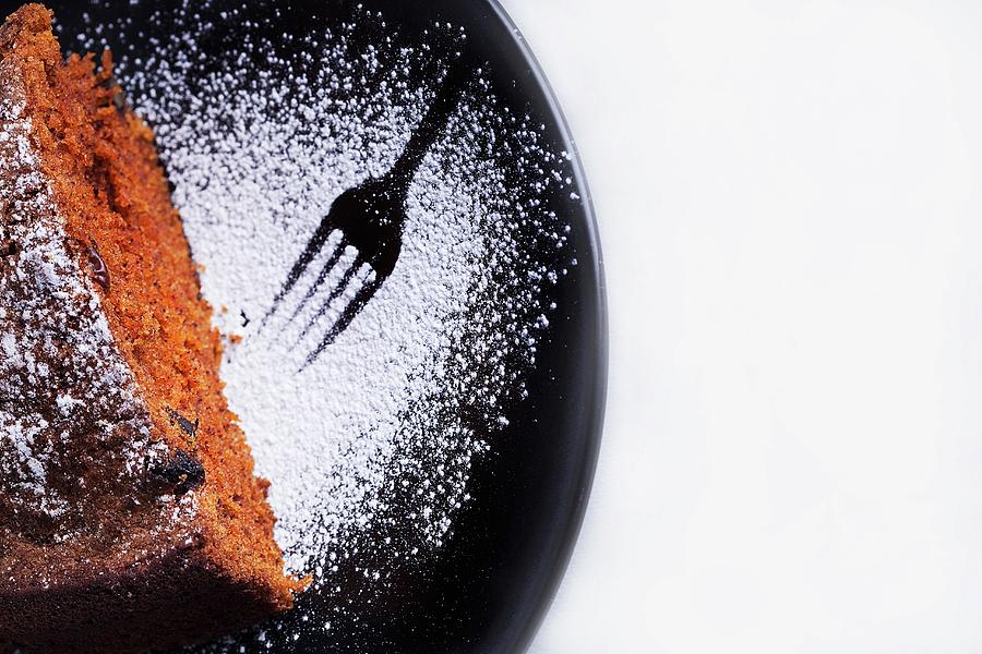 A Slice Of Chocolate Cake On A Plate Dusted With Icing Sugar With A Print From A Fork In The Icing Sugar Photograph by Joanna Ogorek