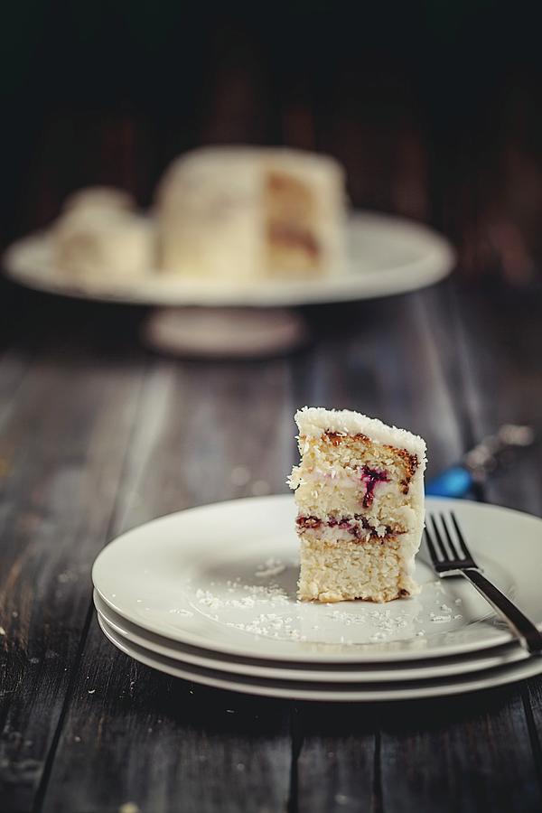 A Slice Of Coconut Cake On A Stack Of Plates Photograph by Susan Brooks-dammann