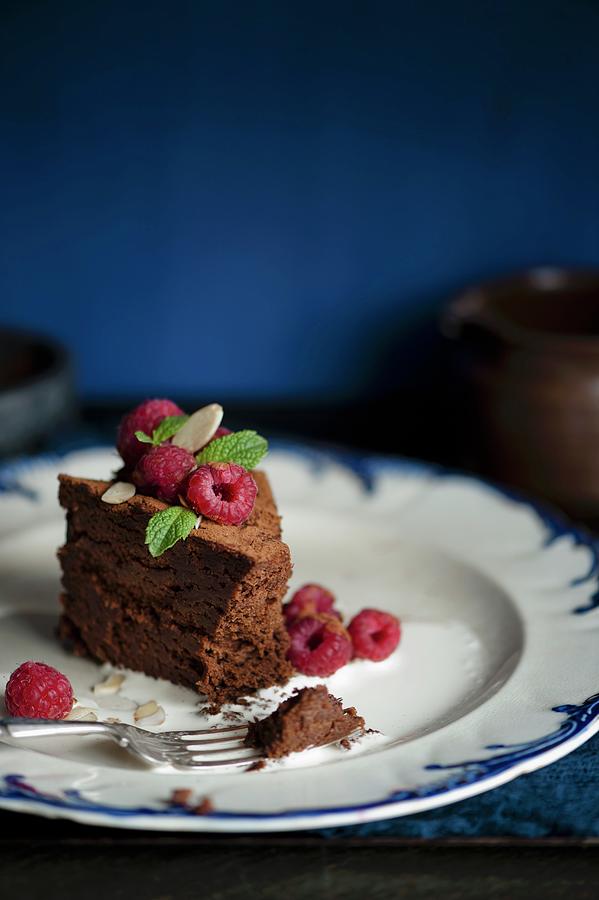 A Slice Of Dark Chocolate Cake With Raspberries, Mint And Liquid Cream Photograph by Magdalena Hendey