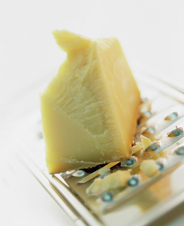 A Slice Of Hard Cheese On A Cheese Grater Photograph by Michael Wissing