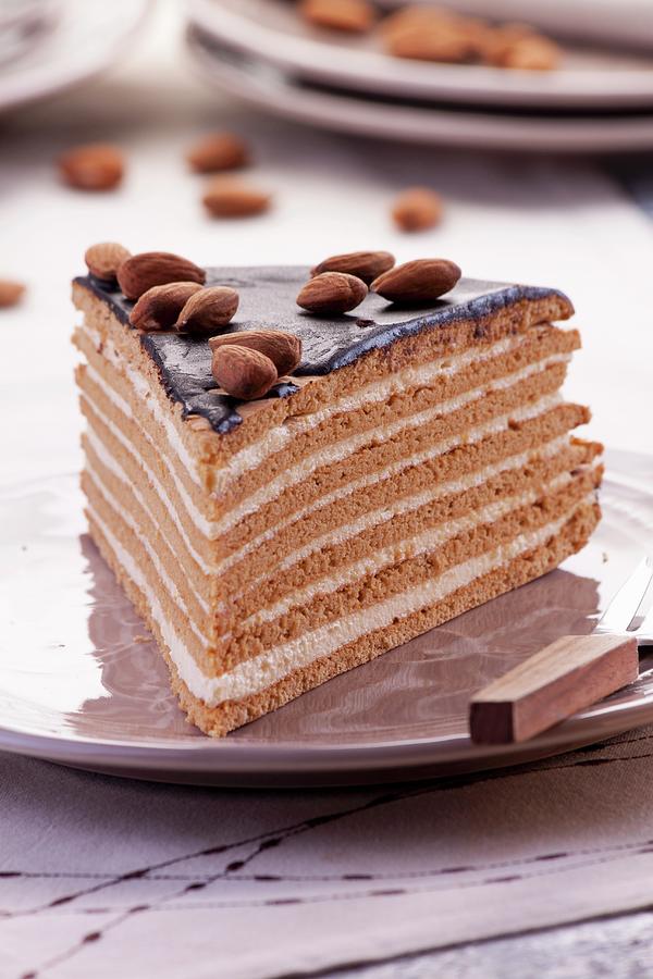 A Slice Of Layered Chocolate, Toffee And Almond Cream Cake Decorated With Almonds Photograph by Wawrzyniak.asia