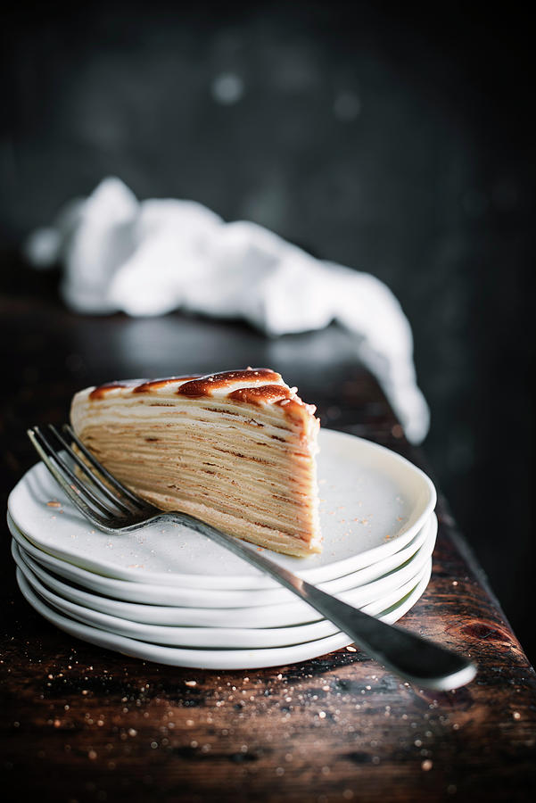 A Slice Of Pancake Cake With Caramel On A Stack Of Plates Photograph by Justina Ramanauskiene