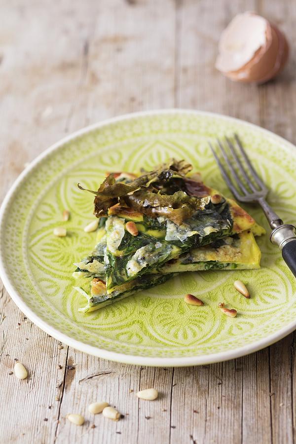 A Slice Of Spinach Tortilla With Seaweed Bacon And Pine Nuts Photograph by Jan Wischnewski