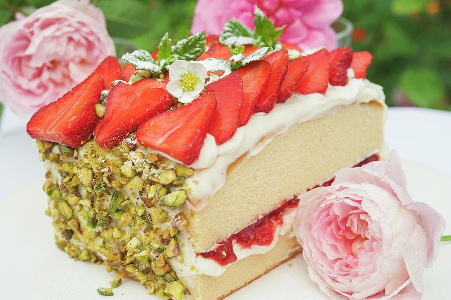 A Slice Of Sponge Cake With Strawberries And Pistachios On A Garden Table Photograph by Linda Burgess