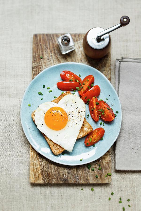 A Slice Of Toast Topped With A Heart-shaped Fried Egg Served With Cherry Tomatoes Photograph by Sporrer/skowronek