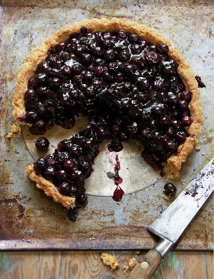 A Sliced Blueberry And Almond Tart On An Old Baking Tray With A Knife Photograph by Atkinson / Sue Dr.