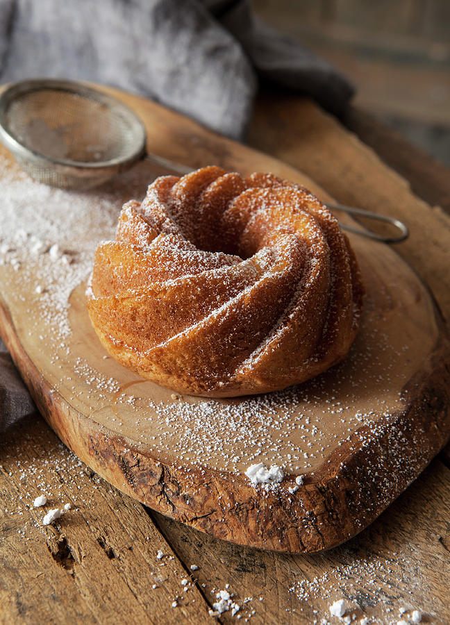 A Small Bundt Cake On A Rustic Wooden Board Photograph by Stacy Grant