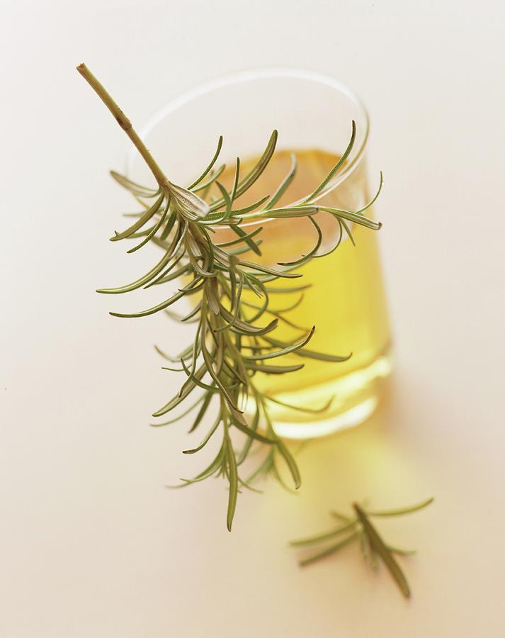 A Small Glass Of Oil With A Sprig Of Rosemary Photograph by Michael Wissing