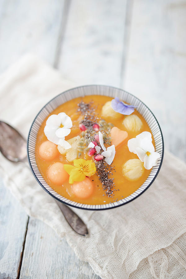 A Smoothie Bowl With Cantaloupe Melon, Pineapple And Coconut Chips Photograph by Jan Wischnewski